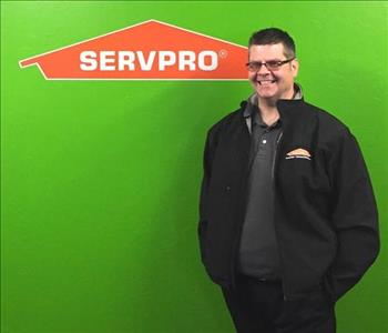 Shawn standing in front of green wall and SERVPRO Logo